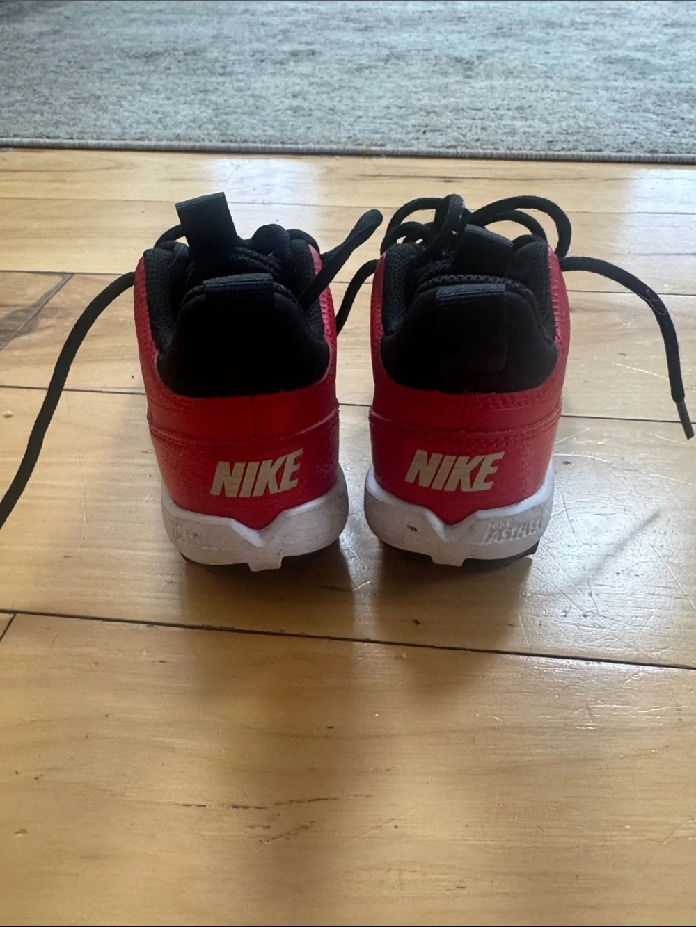 Nike Kids' Red and Black cleats with White Swoosh